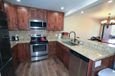 a kitchen with wooden cabinets and stainless steel appliances at Mammoth Ski Racquet Club 12 - Pet Friendly in Mammoth Lakes