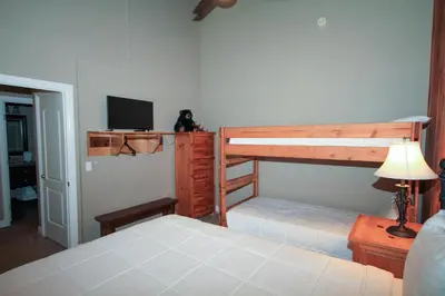 a bedroom with two bunk beds and a television at Mammoth Ski Racquet Club 38 - Pet ok - Loft in Mammoth Lakes