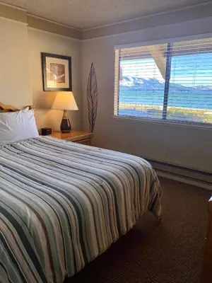 a bedroom with a bed and a large window at Tahoe Lakeshore Lodge & Spa in South Lake Tahoe
