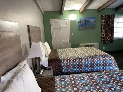a hotel room with two beds and a door at Travel Inn in South Lake Tahoe
