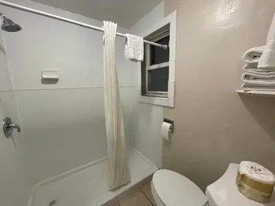 a bathroom with a shower with a toilet and a window at Travel Inn in South Lake Tahoe
