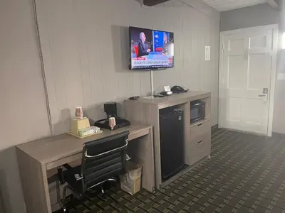 a room with a desk with a television on the wall at Travel Inn in South Lake Tahoe