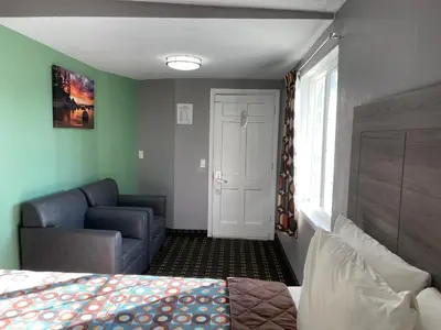 a bedroom with a bed and a couch and a window at Travel Inn in South Lake Tahoe