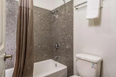 a bathroom with a white toilet and a shower at Motel 6-Westley, CA in Westley