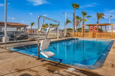 a swimming pool with a chair and a swing at Motel 6-Westley, CA in Westley