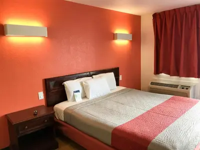 a bedroom with a bed with a red wall at Motel 6-Westley, CA in Westley