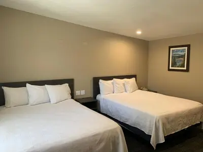 two beds in a hotel room with white sheets at Black Jack Inn in South Lake Tahoe