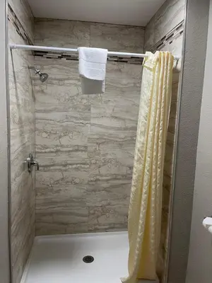 a bathroom with a shower with a white towel at Tahoe Hacienda Inn in South Lake Tahoe