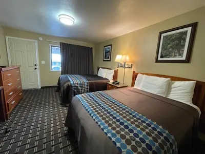 a hotel room with two beds and a dresser at Tahoe Hacienda Inn in South Lake Tahoe