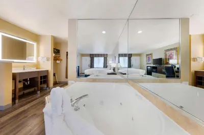 a large bathroom with a tub and a bedroom at Best Western Fallon Inn & Suites in Fallon