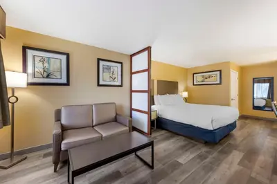 a hotel room with a bed and a chair at Best Western Fallon Inn & Suites in Fallon
