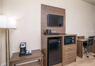 a hotel room with a refrigerator and a tv at Westhaven Inn Pollock Pines Camino in Pollock Pines