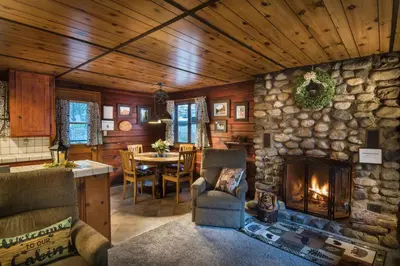 a living room with a stone wall and a fireplace at 16 Chipmunks Holiday in Wawona