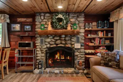 a living room with a stone fireplace in a house at 16 Chipmunks Holiday in Wawona