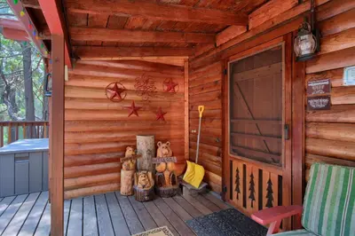 a wooden cabin with a porch with a door at 16 Chipmunks Holiday in Wawona