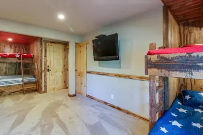 a bedroom with two bunk beds and a flat screen tv at Wooded Escape in Donner Pines Tract