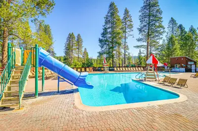 a swimming pool with a slide and a playground at Wooded Escape in Donner Pines Tract