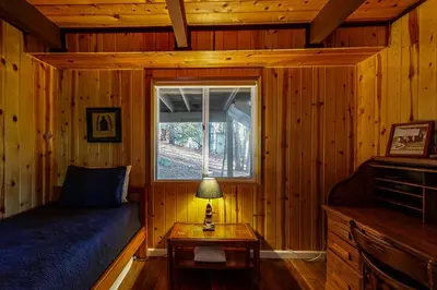 a bedroom with a bed and a window in a cabin at Pine Mountain Magic in Groveland