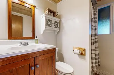 a bathroom with a sink and a toilet and a mirror at Pine Mountain Magic in Groveland