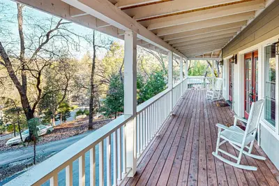 a porch with a white rocking chair on a house at Pine Mountain Magic in Groveland