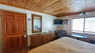 a bedroom with a bed and a dresser and a mirror at Kernville Inn in Kernville