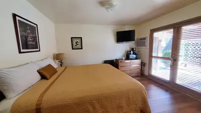 a bedroom with a large bed and a large window at Kernville Inn in Kernville