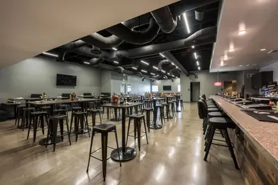 a dining room with tables and bar stools at Studio 6-Mccarran, NV - Sparks - Tahoe - Reno Industrial Center in Clark