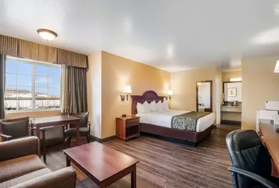 a hotel room with a bed and a living room at SureStay Hotel by Best Western Fernley in Fernley