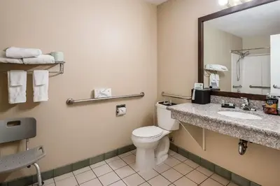 a bathroom with a toilet and a sink and a mirror at SureStay Hotel by Best Western Fernley in Fernley