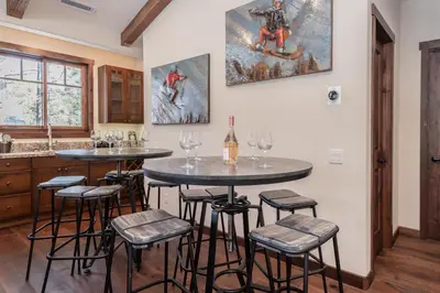 two tables in a kitchen with wine glasses at Gray Bear 454 in Mammoth Lakes