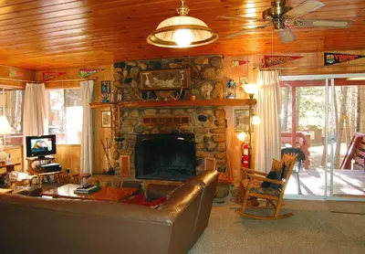 a living room with a couch and a stone fireplace at 28 Raccoon's End in Wawona