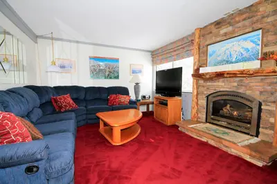 a living room with a blue couch and a fireplace at Mammoth Ski Racquet Club 74 1 Bdrm Loft in Mammoth Lakes