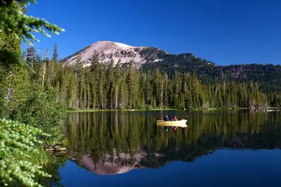 two people in a boat on a lake with a mountain at Mammoth Ski Racquet Club 74 1 Bdrm Loft in Mammoth Lakes