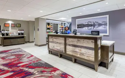 a woman sitting at a reception desk in a hospital lobby at Hampton Inn & Suites Reno/Sparks in Reno