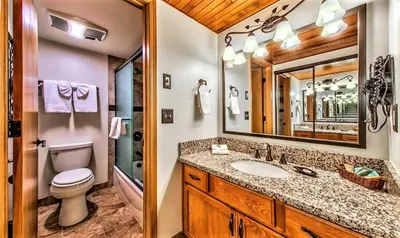 a bathroom with a toilet sink and a mirror at The Tahoe Beach & Ski Club Owners Association in South Lake Tahoe