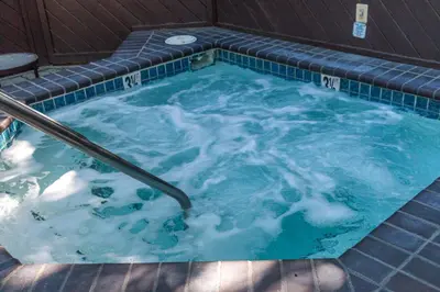 a jacuzzi tub with a hand rail in it at The Tahoe Beach & Ski Club Owners Association in South Lake Tahoe