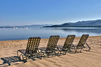 three chairs sitting in the sand on the beach at The Tahoe Beach & Ski Club Owners Association in South Lake Tahoe
