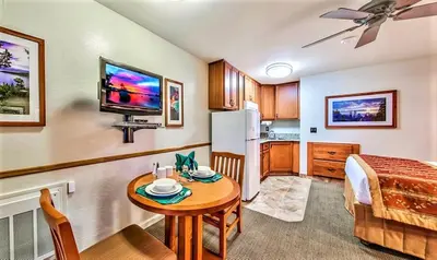 a kitchen and a living room with a table and a refrigerator at The Tahoe Beach & Ski Club Owners Association in South Lake Tahoe
