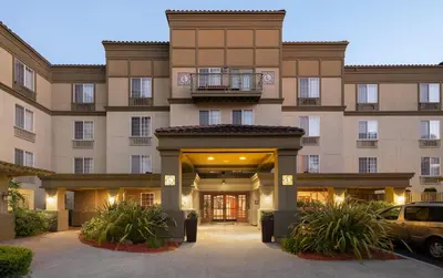 a building with a car parked in front of it at Larkspur Landing Extended Stay Suites Roseville in Roseville