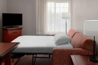 a living room with a couch and a flat screen tv at Larkspur Landing Extended Stay Suites Roseville in Roseville