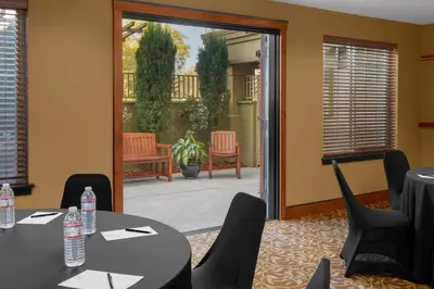 a conference room with tables and chairs and a patio at Larkspur Landing Extended Stay Suites Roseville in Roseville
