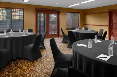 a conference room with tables and chairs with water bottles on them at Larkspur Landing Extended Stay Suites Roseville in Roseville