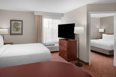 a hotel room with two beds and a flat screen tv at Larkspur Landing Extended Stay Suites Sacramento in Sacramento