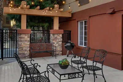a patio with chairs and a table in front of a building at Larkspur Landing Extended Stay Suites Sacramento in Sacramento