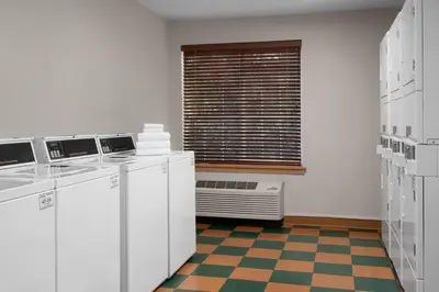 a kitchen with white appliances and a window with a radiator at Larkspur Landing Extended Stay Suites Sacramento in Sacramento