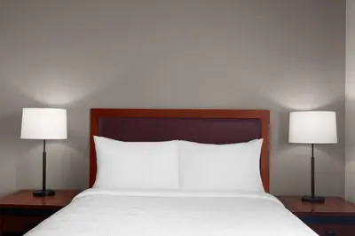 a bedroom with a bed with two lamps on tables at Larkspur Landing Extended Stay Suites Folsom in Folsom