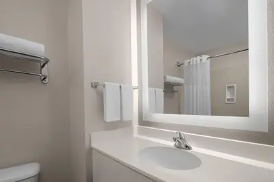 a white bathroom with a sink and a mirror at Larkspur Landing Extended Stay Suites Folsom in Folsom