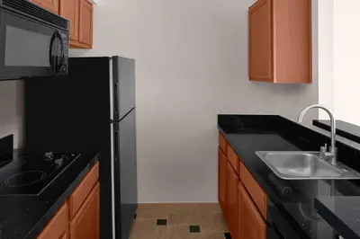 a kitchen with a black refrigerator and a sink at Larkspur Landing Extended Stay Suites Folsom in Folsom