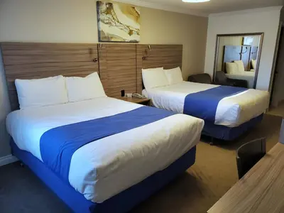 a hotel room with two beds and a mirror at Exchange Club Motel in Beatty
