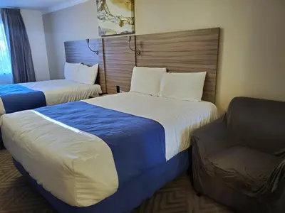 a hotel room with two beds and a couch at Exchange Club Motel in Beatty